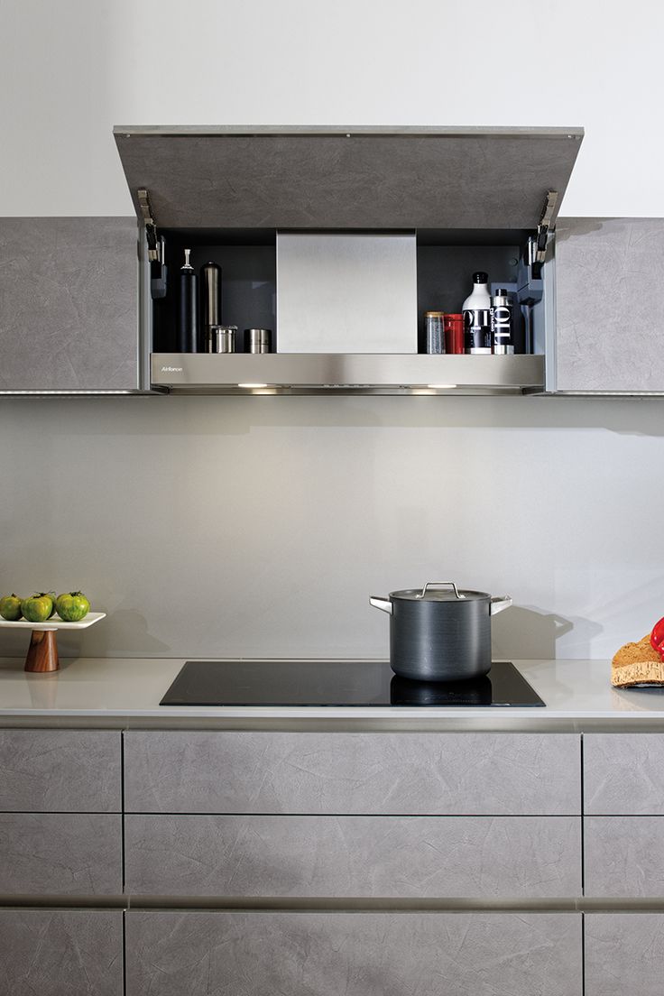 a stove top oven sitting inside of a kitchen next to a wall mounted pot and pan