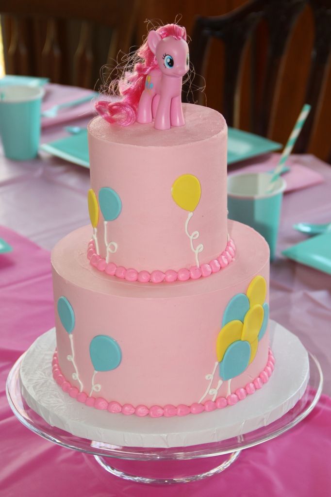 a pink and blue cake with a pony on top