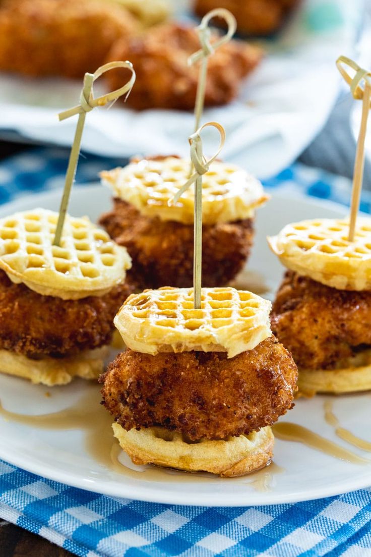 fried chicken and waffle sandwiches on a plate with toothpicks in the middle