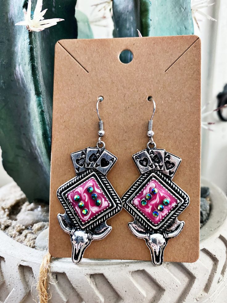 Channel your inner cowgirl with the Luck of the Draw Earrings. These earrings are a lucky gamble for any outfit, featuring a playful design with a touch of western flair. Embrace your wild side and let these earrings bring you some good luck (and compliments)! Burnished Silver and Pink Color Size : 5 cm x 2.5 cm Playful Design, Good Luck, Pink Color, Bring It On, Let It Be, Silver, Pink, Color, Design