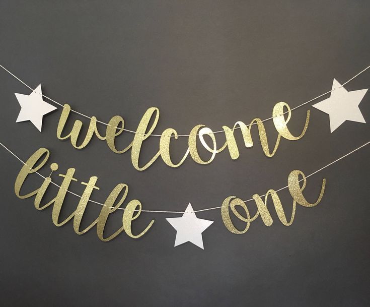 a welcome little one banner with stars hanging from it's side on a string