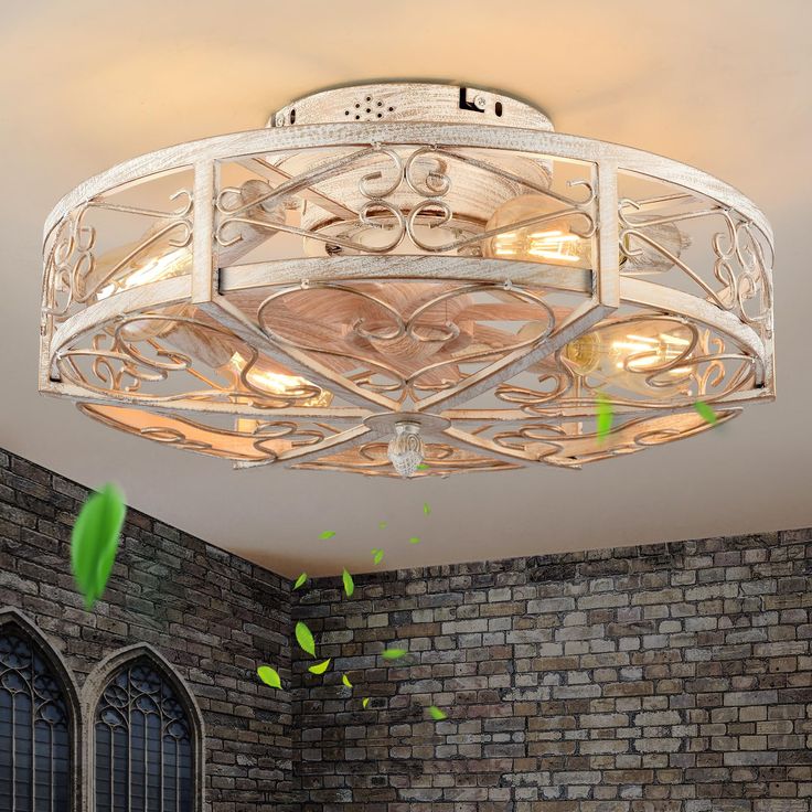 an ornate ceiling light fixture in a room with brick walls and arched windows on either side