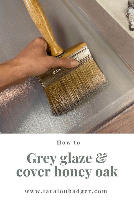 a person using a brush to clean the top of a table with gray glaze and cover honey oak