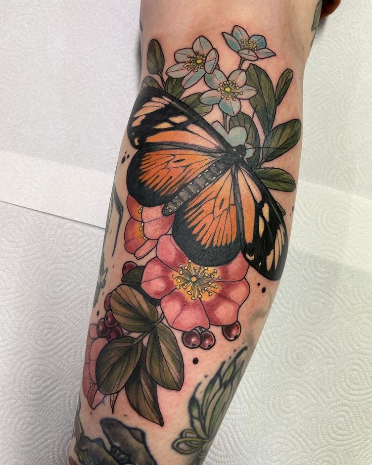 a woman's leg with flowers and a butterfly on it, which is also in color