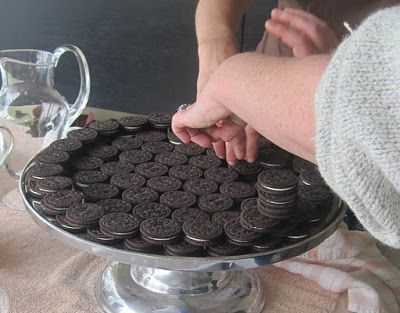 a person placing oreo cookies on top of a cake