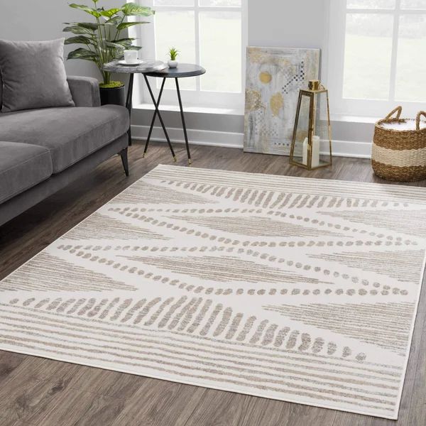 a living room with a gray couch and white rugs on the hardwood flooring