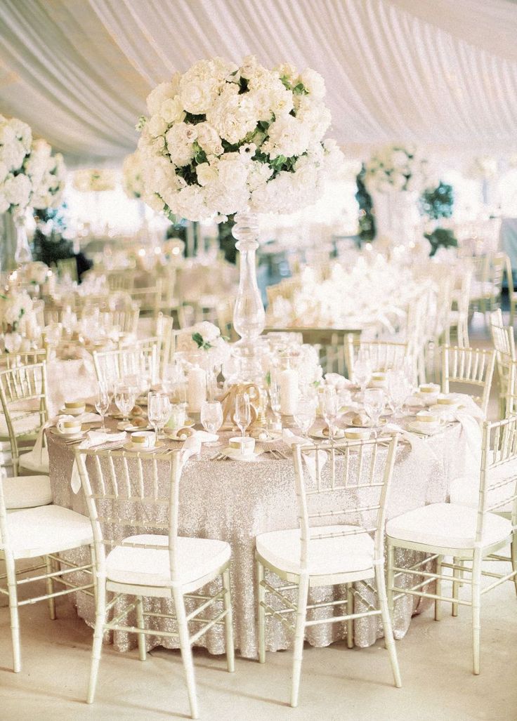 the tables are set with white flowers and chairs