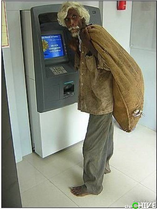 an old man with a bag on his back standing in front of a atm machine