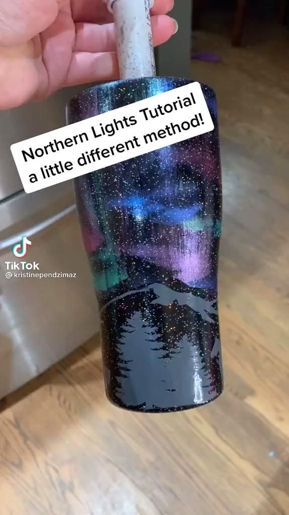 someone is holding up a cup with the words northern lights on it and there are stars in the sky