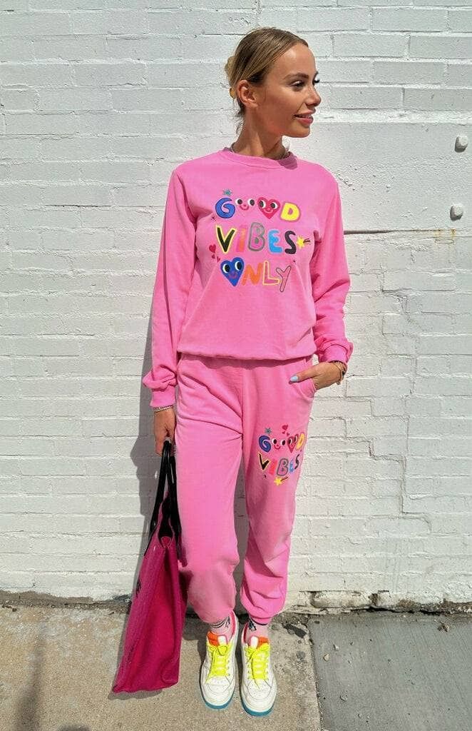 Description: Cheerful two-piece set featuring a bright pink sweatshirt and matching joggers with colorful "Good Vibes Only" text and playful heart accents. The relaxed-fit top and elastic-waist joggers with pockets provide comfort and functionality for everyday wear. Perfect for casual outings or spreading positivity wherever you go. Material & Care: Made from a soft and breathable cotton-blend fabric for all-day comfort and durability. Machine wash cold with similar colors; tumble dry low or la Comfortable Long Sleeve Pink Set, Trendy Lounging Sets For Spring, Trendy Spring Lounging Sets, Cozy Pink Loungewear Sets, Pink Crew Neck Sets For Winter, Pink Crew Neck Winter Sets, Trendy Long Sleeve Loungewear Sets, Trendy Loungewear Sets For Fall, Trendy Pink Sets For Fall