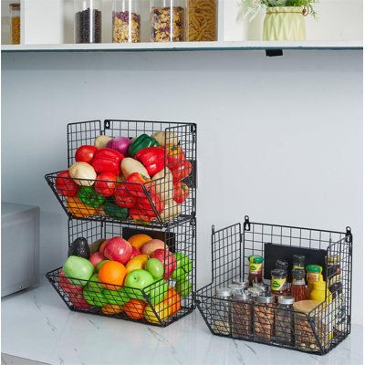 two metal baskets filled with fruit on top of a counter