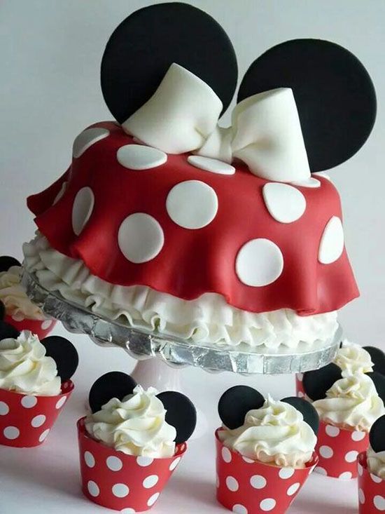 a minnie mouse cake and cupcakes on a table