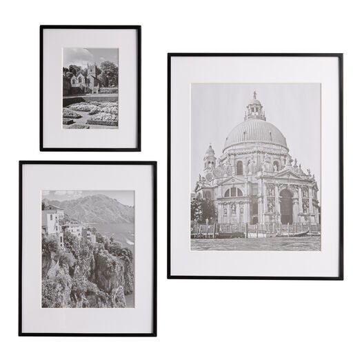 three black and white photographs hanging on the wall next to each other, one with a building