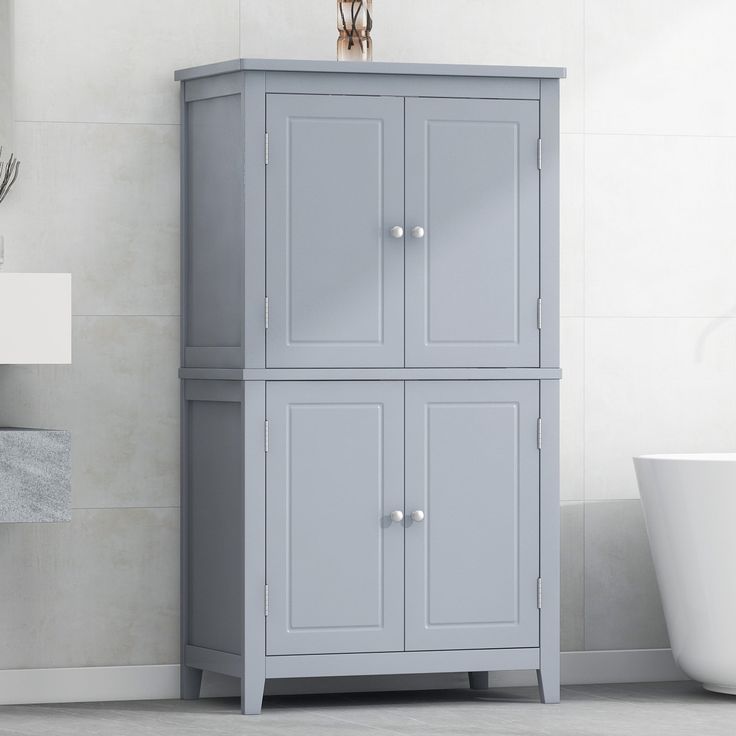 a bathroom with a gray cabinet next to a white bath tub