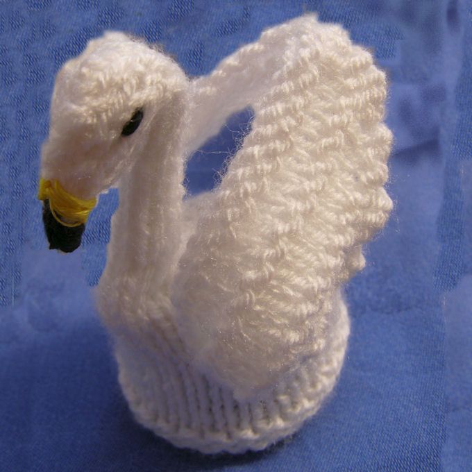 a white knitted swan ornament on a blue background