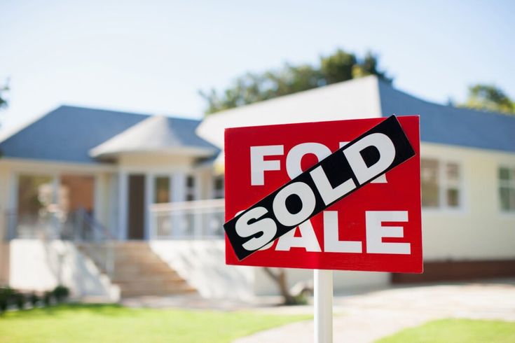 a for sale sign in front of a house