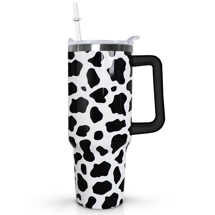 a black and white cow print travel mug with a straw sticking out of the handle