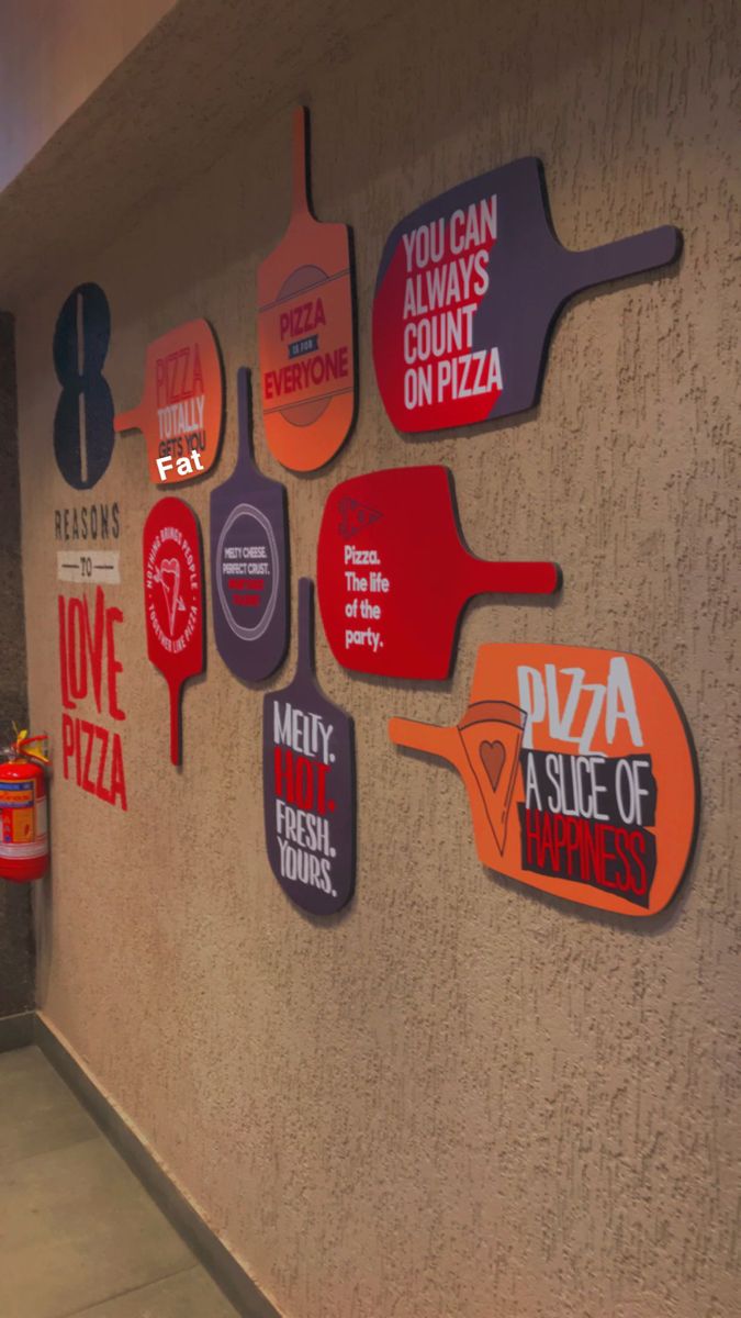 there are many pizza signs on the wall