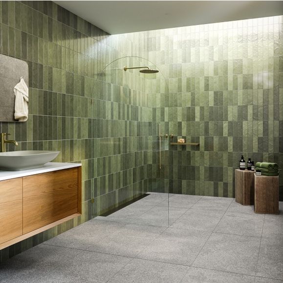 a bathroom with green tiles on the walls