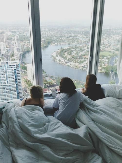 three women sitting on a bed looking out the window with text over them that reads people watch together