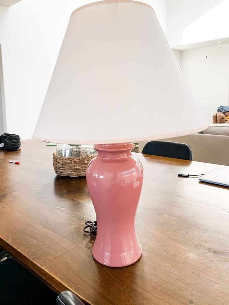 a pink lamp sitting on top of a wooden table