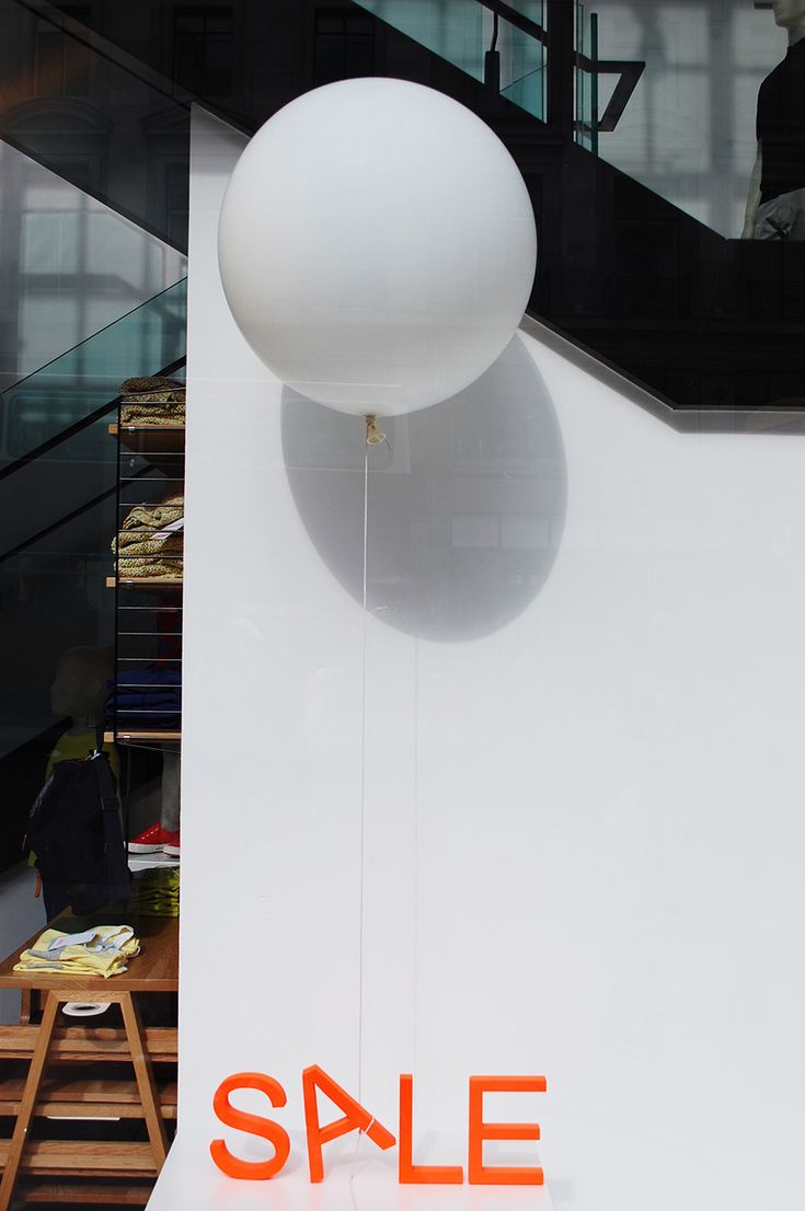 an orange sale sign hanging from the side of a wall next to a white ball