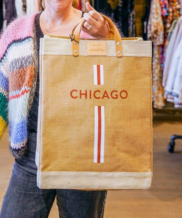 Get everything done with this durable Chicago market bag made exclusively for Art Effect! This best-selling canvas bag features soft leather handles for easy carry, a tough and spill-proof inner lining, and a chic look that's sure to turn heads. 100% natural jute with polyurethane lining 13" W x 18" H x 8"D ; 3.5" strap drop, with a 6" x 7" inside pocket Handcrafted by Fair Trade workers in India as part of the Bangladesh Project Brown Shopping Bags With Reinforced Handles, Beige Shopping Bags With Reinforced Handles, Beige Shopping Bag With Reinforced Handles, Casual Natural Canvas Bag For Shopping, Rectangular Waxed Canvas Shopping Bag, Waxed Canvas Rectangular Shopping Bag, Summer Canvas Bag For On-the-go, Beige Burlap Shopping Bag, Trendy Canvas Shopping Bag With Leather Handles