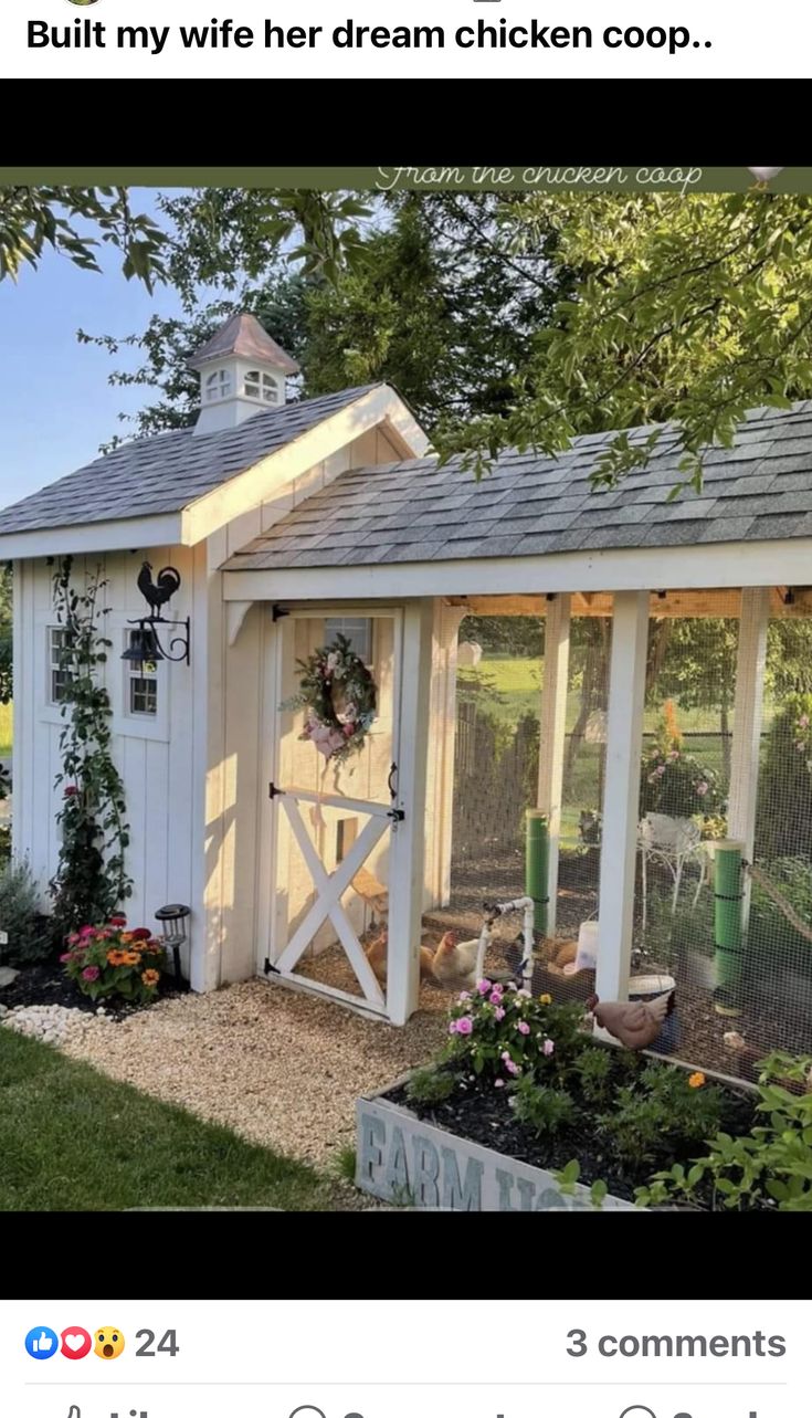 a small chicken coop in the yard with flowers and plants around it, next to a fence