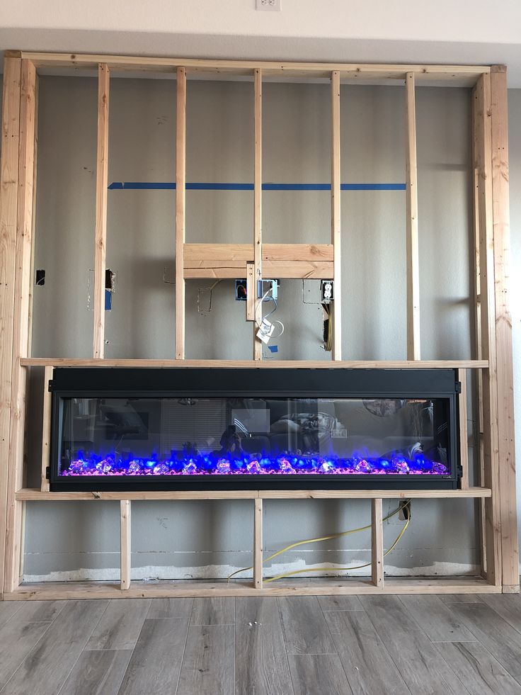 an electric fireplace with blue flames in a room that is being built into the wall