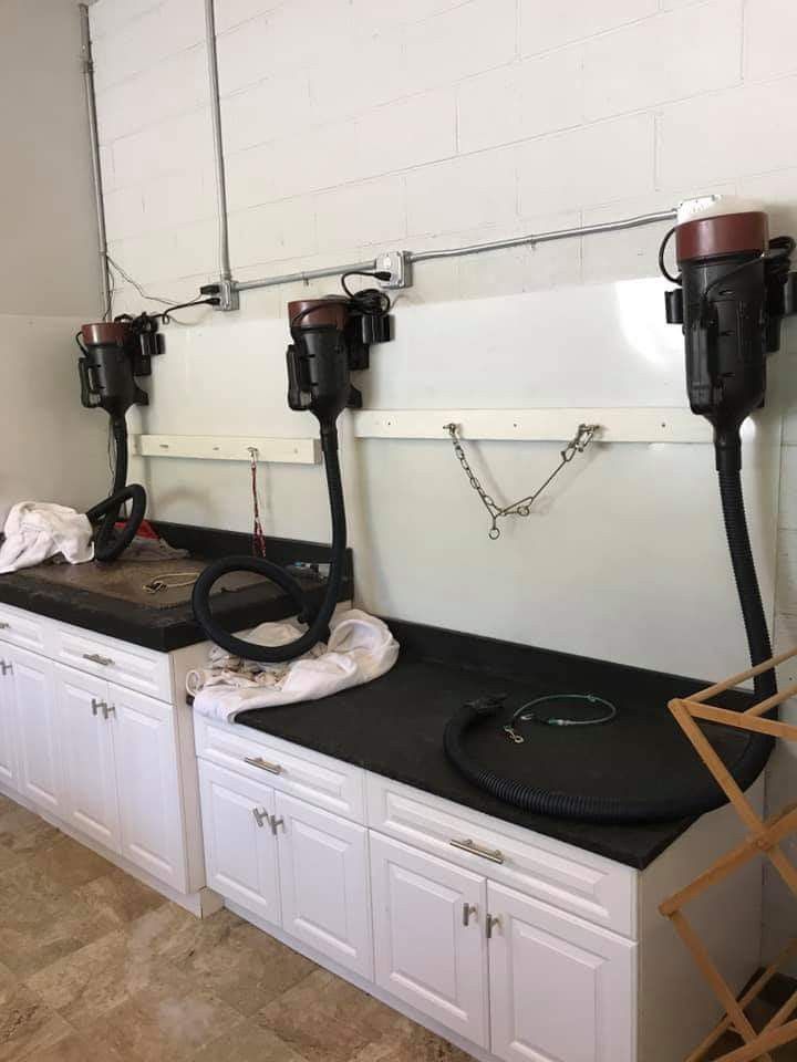 a kitchen with white cabinets and black counter tops, including two vacuums on top of the stove