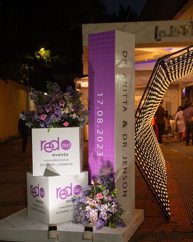 flowers are placed on top of boxes in front of a sign that reads red, white and purple