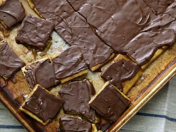 a pan filled with chocolate frosted squares on top of a table