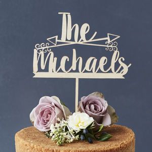 a cake topped with a wooden sign and flowers