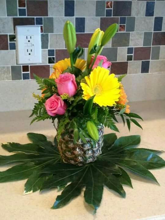 a vase filled with flowers on top of a counter next to a tile backsplash