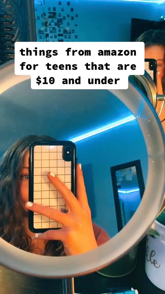 a woman is looking at her phone in the mirror with text that reads, things from amazon for teens that are $ 19 and under