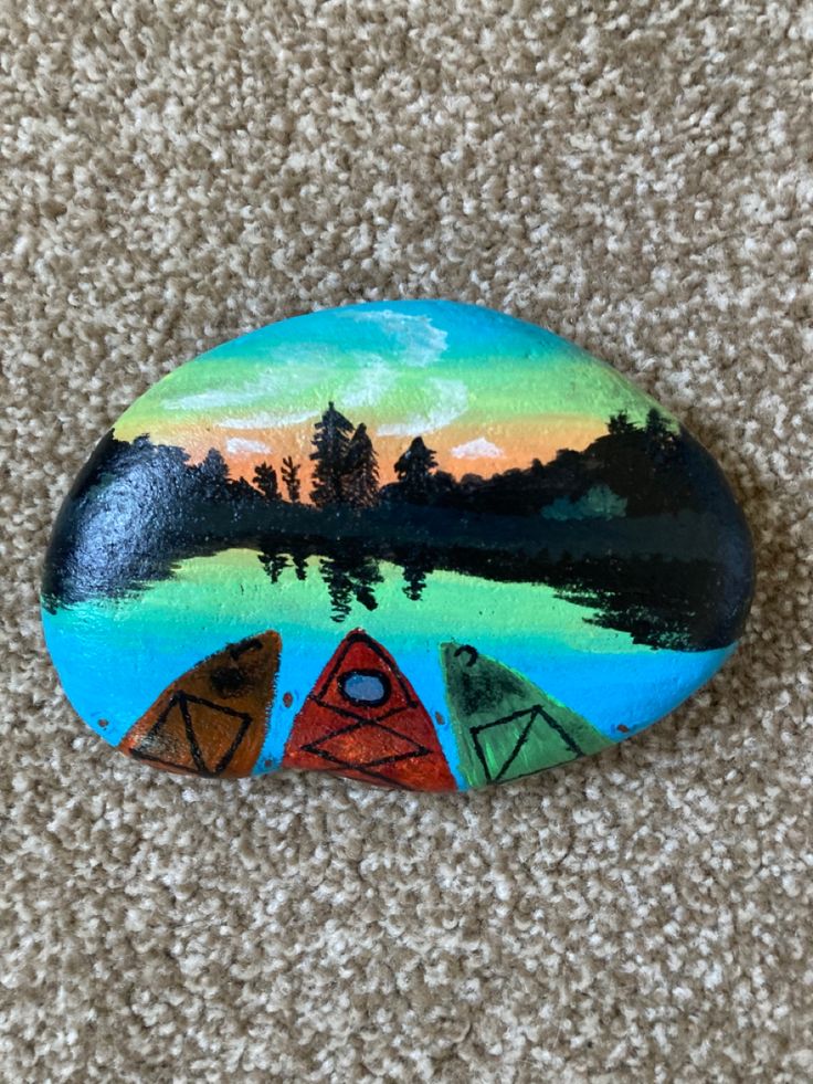 a painted rock sitting on top of a carpet covered floor