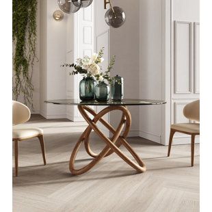 a glass table with some vases on top of it and two chairs in the background