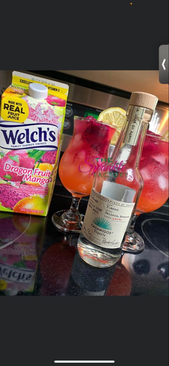 a bottle of alcohol sitting on top of a counter next to a glass filled with liquid