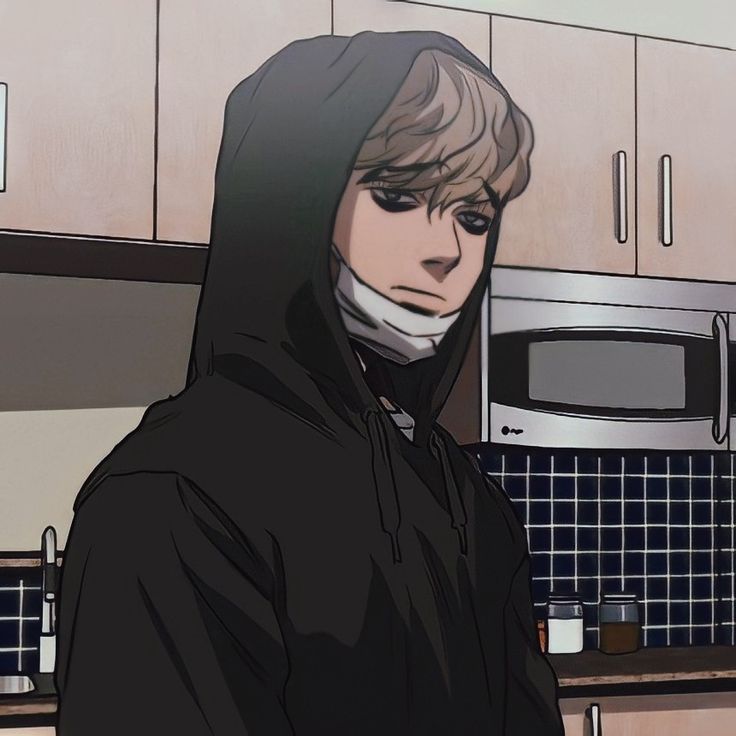 a person in a black hoodie standing in a kitchen