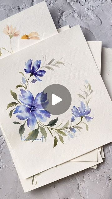 three cards with watercolor flowers on them, one is white and the other is blue