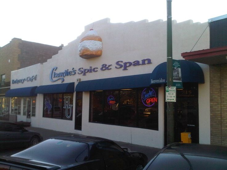 an outside view of a store with cars parked on the street in front of it