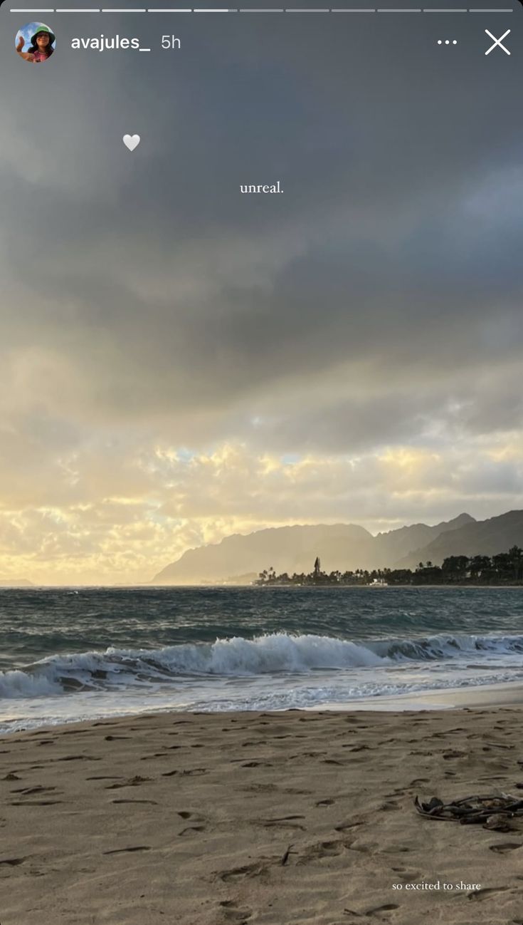 an image of the beach with waves coming in from the water and clouds above it