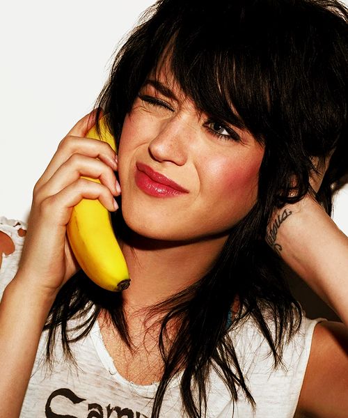 a woman holding a banana up to her ear