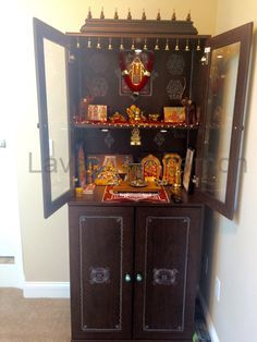 a wooden cabinet with many items on it in a room that has carpeted flooring and white walls