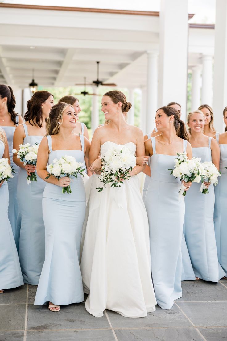 the bride and her bridesmaids are all laughing together in their blue gowns