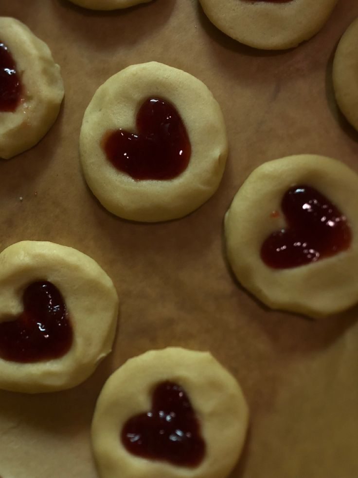 heart shaped cookies sitting on top of a cookie sheet covered in jams and ketchup