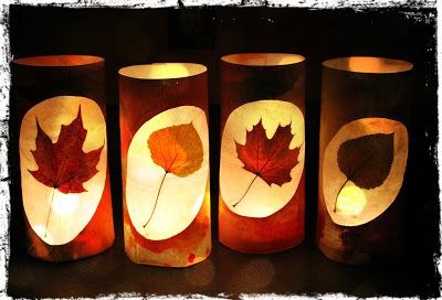 four lit candles with leaves on them