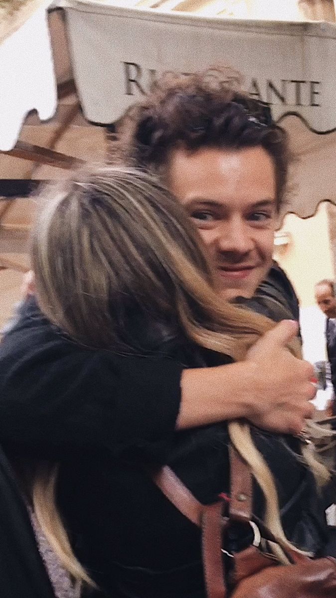 a man and woman hugging each other outside