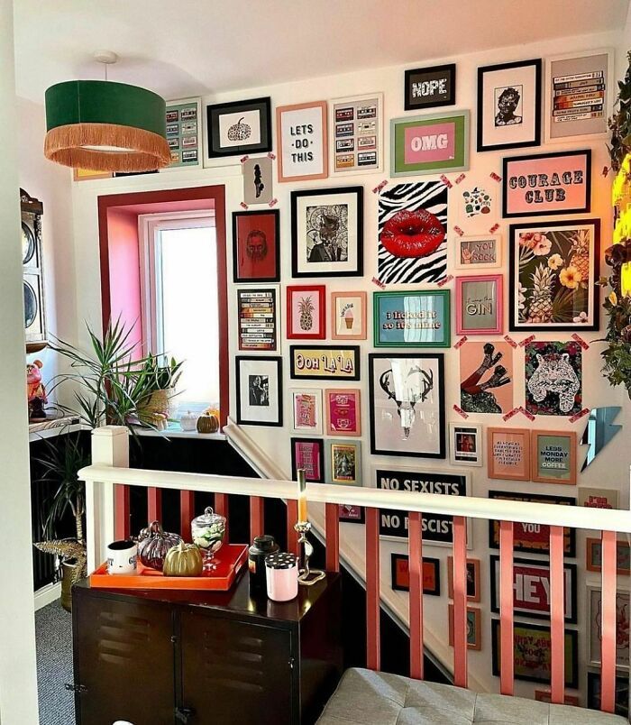 a living room filled with lots of pictures on the wall next to a chair and table