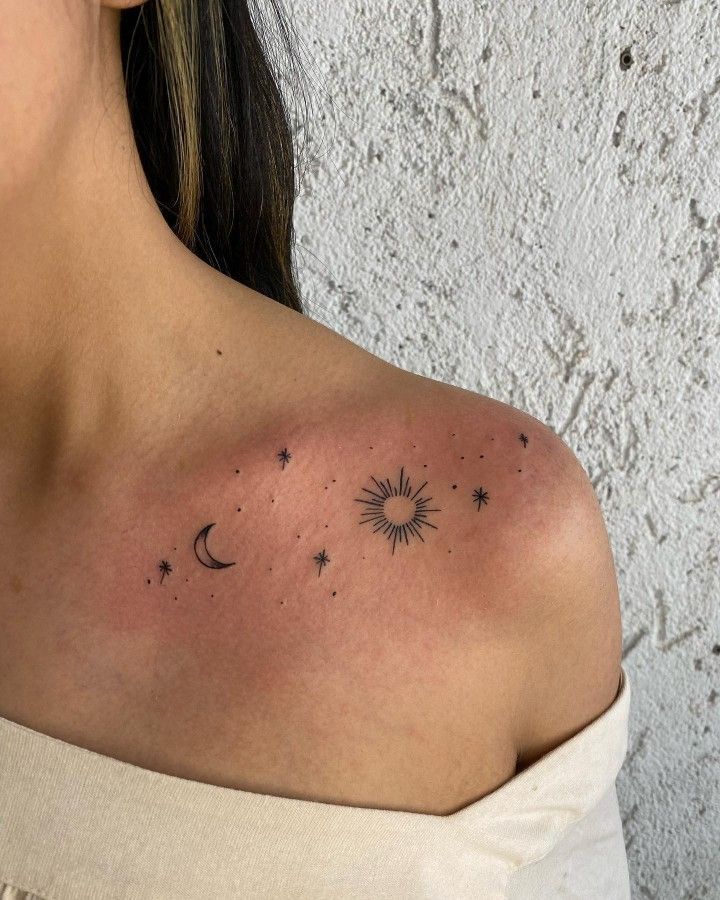 a woman's shoulder with stars and the moon on it